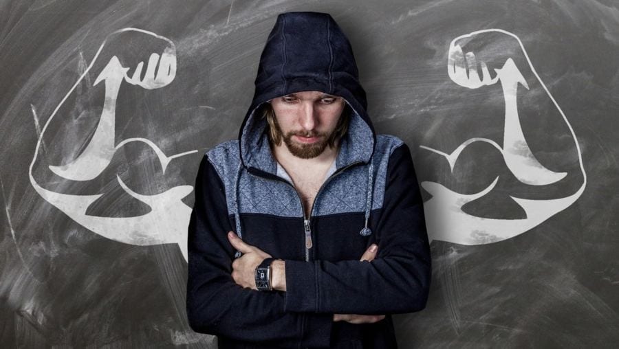homem com blusa em dúvida sobre o melhor para seus músculos