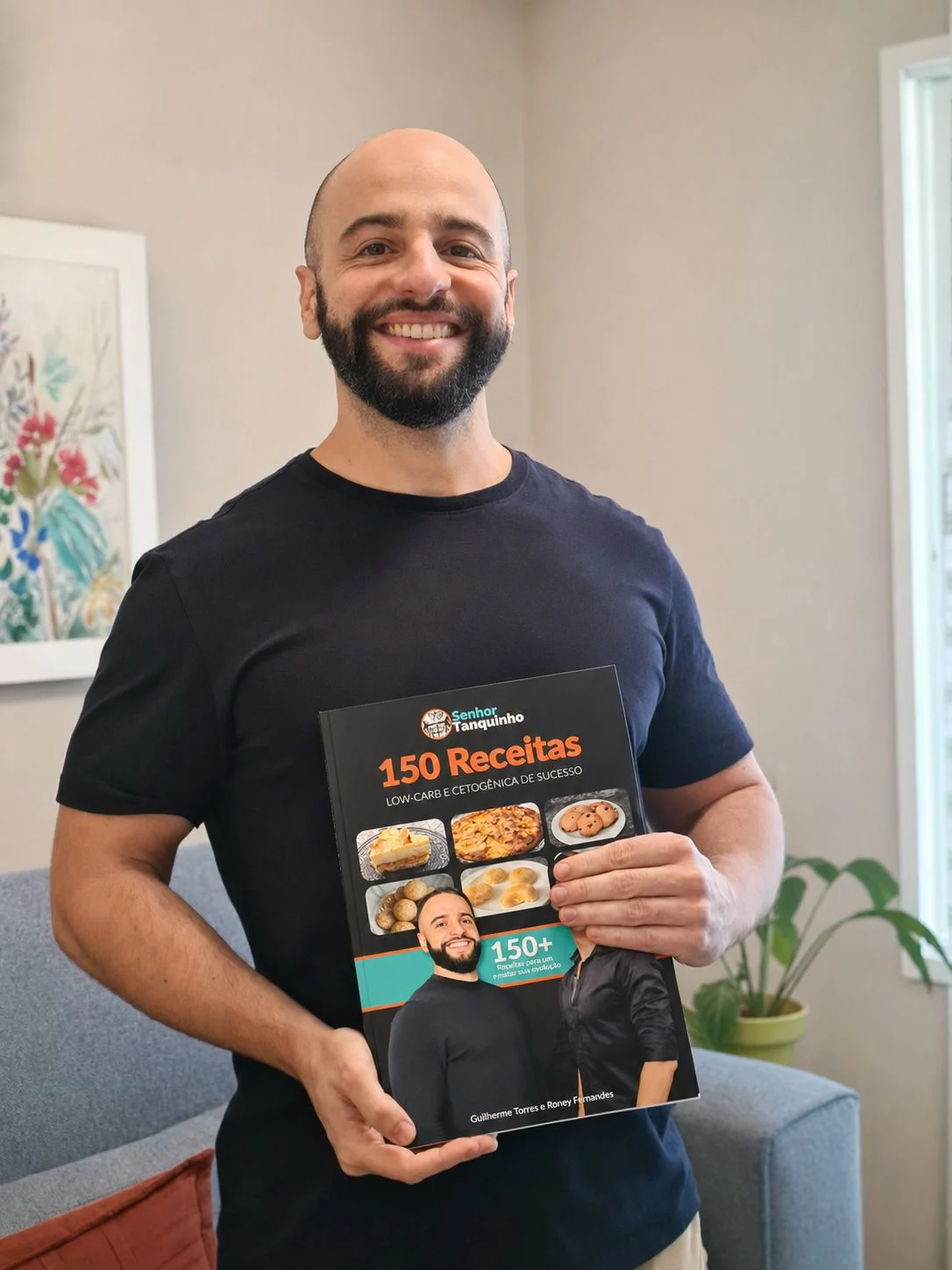 Guilherme segurando o livro 150 Receitas Low-Carb e Cetogênicas de Sucesso